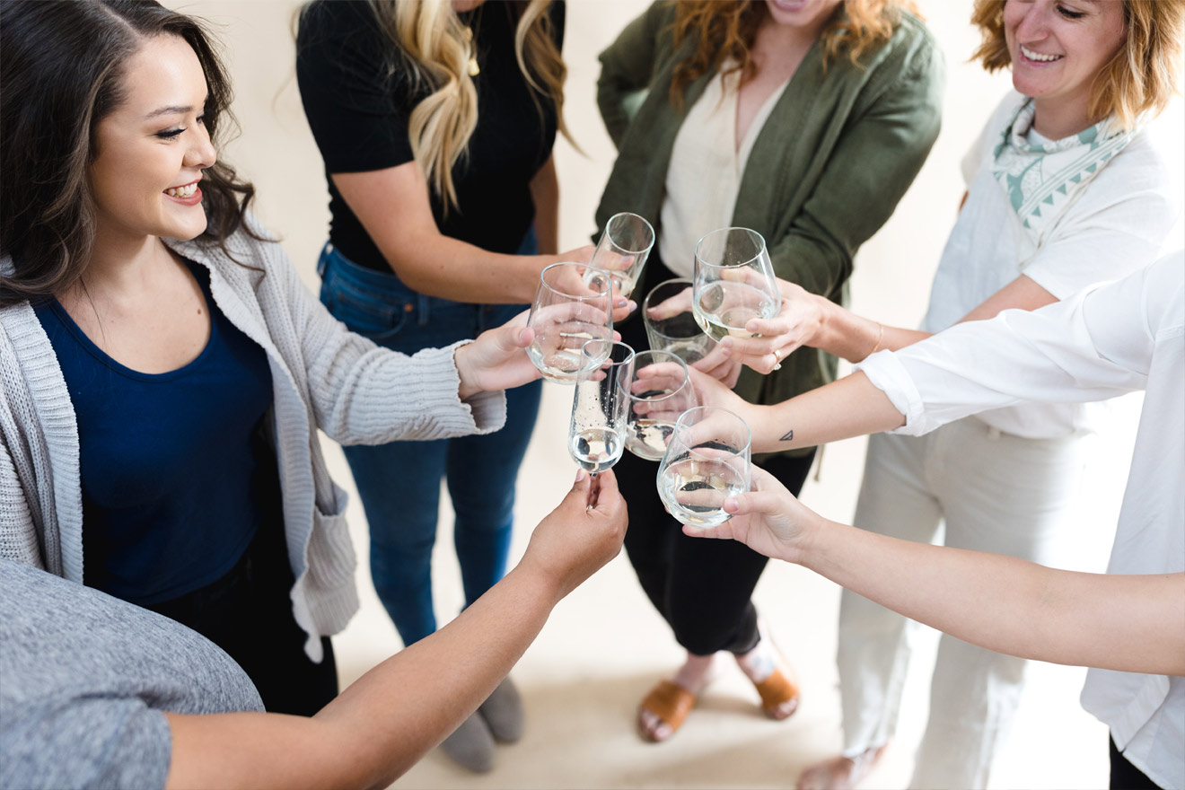 group of women cheering wine glasses